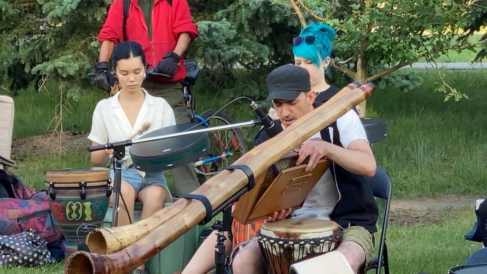 Facilitators playing didgeridoo and drums outdoors at Drumming in the Park near the Weaselhead in Calgary