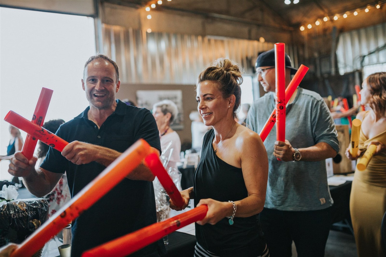 Colleagues laughing as they play rhythm instruments together at a corporate team building event in Calgary