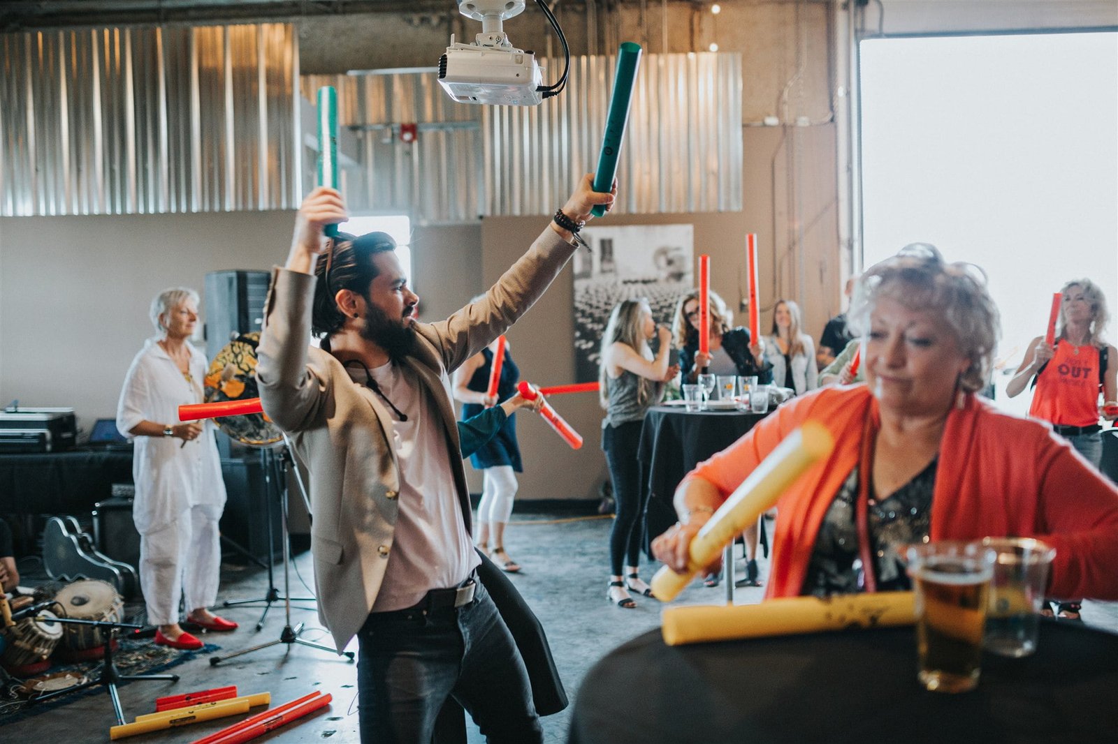 Guests at a Calgary corporate event playing colourful Boomwhackers together in an interactive drum circle