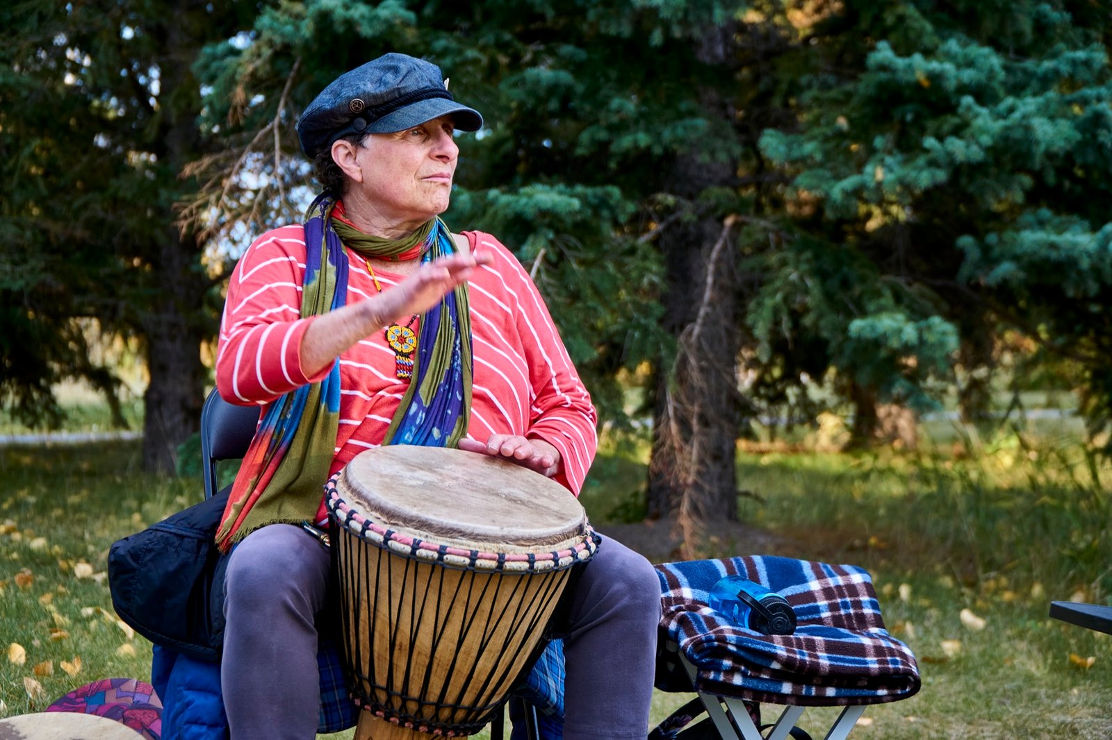 Care staff learning to lead a seated drum circle with frame drums and shakers during ICDC facilitator training